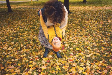 Annem ve onun oğlu çocuk çocuk oynamaya ve sonbahar parkta sarılma