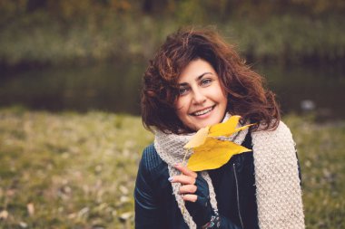 Sarı sonbahar sonbahar kadınla yaprak Park'ta bir soğuk rüzgarlı gün açık havada, portre