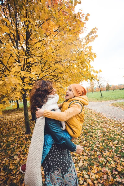 Aile açık havada eğleniyor. Anne ve çocuk sarılma. 
