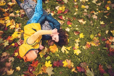 Mutlu bir aile açık havada eğleniyor. Anne ve çocuk oyun park sarılma
