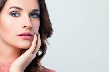 Onun yüzünü el güzel kadın ona dokunmayı. Mükemmel kız makyaj afiş arka plan ile. Doğal güzellik