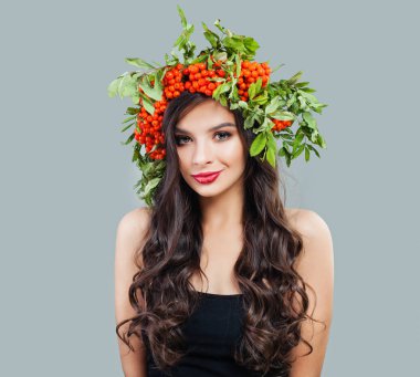 Güzel esmer kadın moda modeli ile sağlıklı kıvırcık saç modeli, makyaj ve kırmızı çilek ve yeşil yaprakları, portre