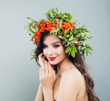 Esmer kadın gülümsüyor. Mutlu moda modeli kız sağlıklı kıvırcık saç modeli, makyaj ve kırmızı çilek ve yeşil yaprakları ile 