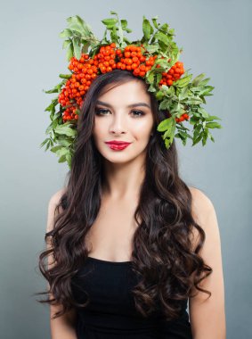 Güzel esmer kadın moda modeli ile sağlıklı kıvırcık saç modeli, makyaj ve kırmızı çilek ve yeşil yaprakları, portre