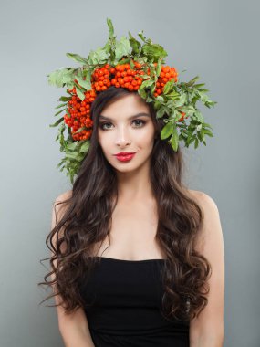 Esmer kadın moda model sağlıklı kıvırcık saç modeli, makyaj ve kırmızı çilek ve yeşil yaprakları ile