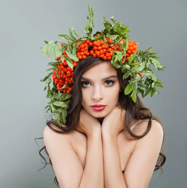 黑发妇女与健康卷曲的发型 妆和红色浆果和绿叶 — 图库照片