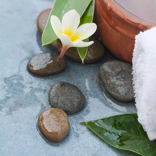 Steine Mit Blume Für Massagebehandlung Auf Blauem Tischhintergrund — Stockfoto