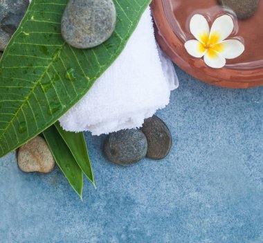 Tropikal yaprak ve çiçek ve taşlar için spa salon tedavi mermer zemin üzerine üstten görünüm.