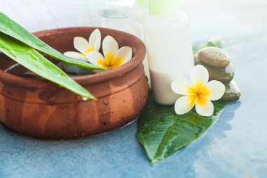 Spa nesneleri havlu ile taşlar için güneş ışığı ile mavi arka plan üzerinde tedavi masaj.