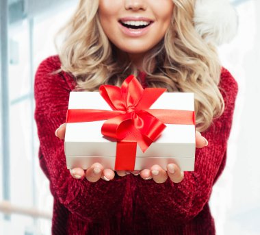 Eller beyaz zemin üzerine kırmızı kurdele ile beyaz Noel hediye kutusu