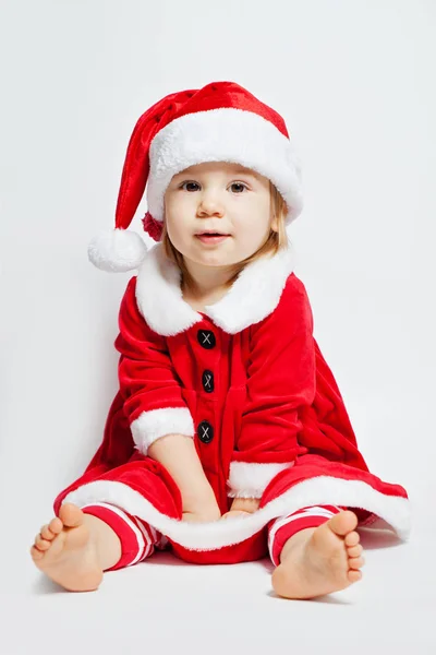 クリスマス サンタ帽子白の背景の上に座って子供女の子 — ストック写真