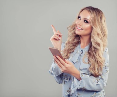 Smartphone kullanarak ve kopya alanı üzerinde yukarıyı mutlu kadın. Cep telefonu ile kız