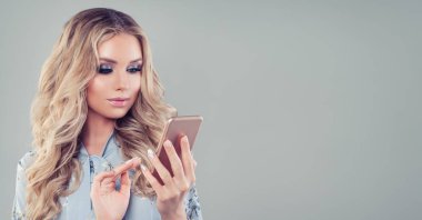 Kadın telefonda boş afiş arka plan üzerinde. Telefon portre ile kız