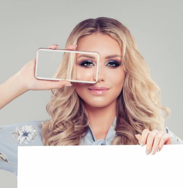 Pazarlama, seo veya ürün yerleştirme reklam için smartphone ve beyaz boş kağıt kurulu afiş arka plan ile gülümseyen kadın