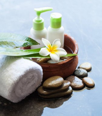 Kâse su krem tüpleri, beyaz havlu ve çiçek