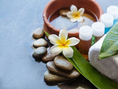 Tropik çiçekler, su, havlu ve krem tüp kase ile güzel spa kompozisyon. Vücut bakımı ve spa konsept