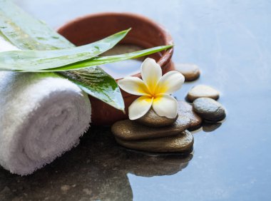 Spa nesneleri ve siyah arka plan üzerine masaj için çiçek.