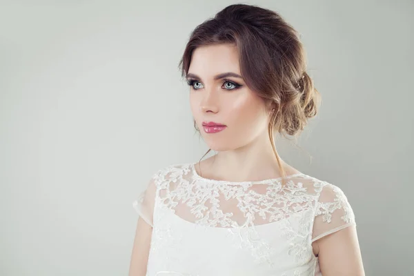 Glamorous woman with perfect makeup and bridal hair on white background, female face closeup