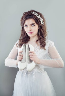 Beyaz Gelin Ayakkabıları tutan güzel gelin kadın. Nişanlısı gelinlik