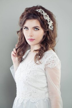 Beyaz gelinliğin içinde sevimli kadın gelin. Düğün saç ve makyaj