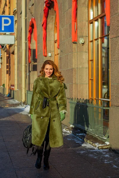 Elegant woman in winter coat walking in the city