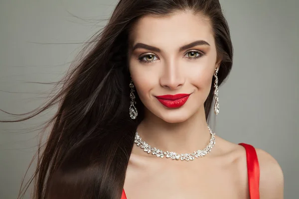 Smiling brunette woman with jewelry diamond necklace and earrings, fashion portrait