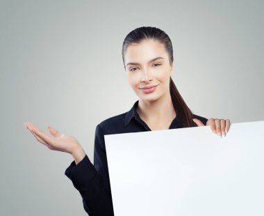 Şirin iş kadını boş açık el ve beyaz boş kağıt afiş arka plan ile. Genç kadın gülümsüyor. İş ve eğitim kavramı