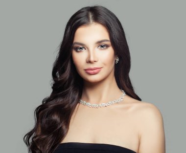 Esmer kız takı ile. Makyaj, uzun saç ve kolye ile sevimli kadın