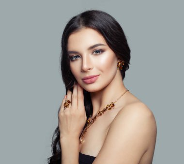 Sevimli kadın kıvırcık saç, makyaj ve altın yüzük, kolye, küpe Amber