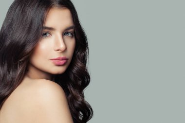 Genç kadın yüzü. Sağlıklı cilt, uzun kıvırcık saç