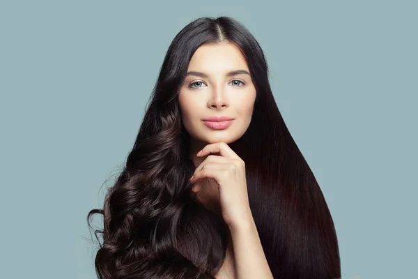 Gülümseyen kadın sağlıklı düz saçlı ve mavi arka plan, moda portre üzerinde mükemmel kıvırcık saç modeli