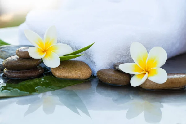 Spa flowers and stones with towel for massage treatment