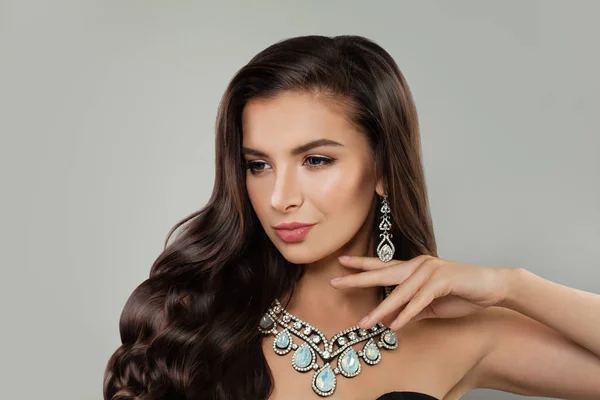Cute brunette woman with makeup, shiny hair and luxurious diamond necklace