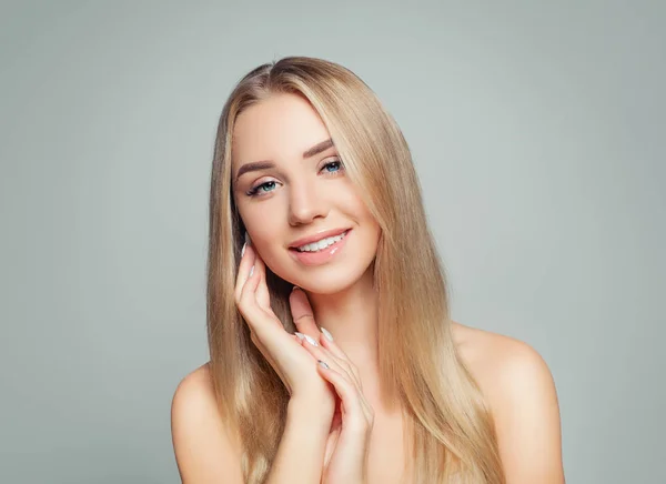 Happy woman with healthy hair and skin. Blonde girl smiling. Facial treatment, haircare and cosmetology