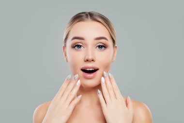 Sürpriz kadın açık ağızlı. Sağlıklı cilt temizlemek ve manikürlü eller ile mutlu kız. Yüz tedavi, kozmetik ve manikür kavramı