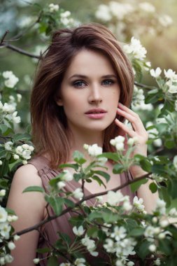 Bahar kadın yüzü. Genç kadın bahar çiçekleri üzerinde model. 