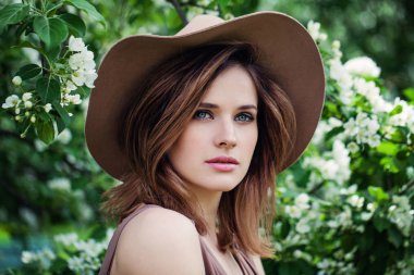 Bahar elma çiçek backgroung üzerinde şapkalı güzel kadın modeli