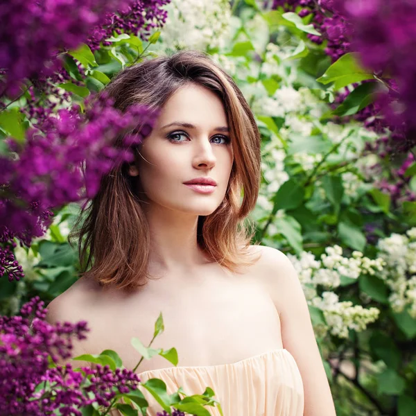Pretty brown-haired girl with layered hair haircut in flowers ou — Stock Photo, Image