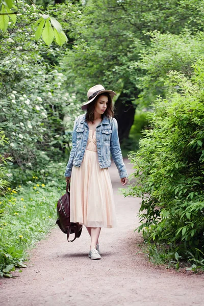 Menina com uma mochila andando no parque ao ar livre — Fotografia de Stock