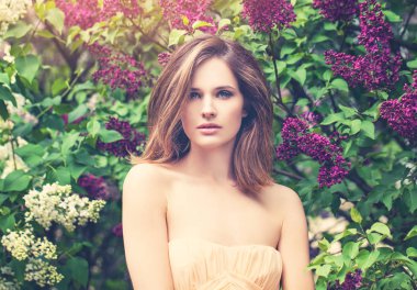 Eflatun çiçekler ve yeşil yaprakları arka plan üzerinde sevimli kadın. Mükemmel