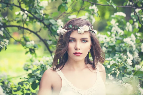 Bonito jovem mulher no primavera flores e verde folhas fundo . — Fotografia de Stock