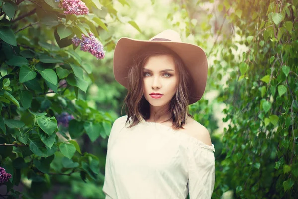 Mujer de moda de primavera en el sombrero en el fondo de la flor. Estilo de país —  Fotos de Stock