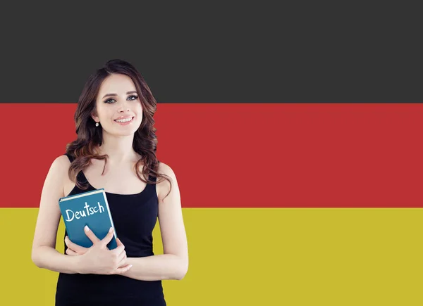 Изучайте немецкий язык. Привлекательная молодая женщина с разговорником — стоковое фото