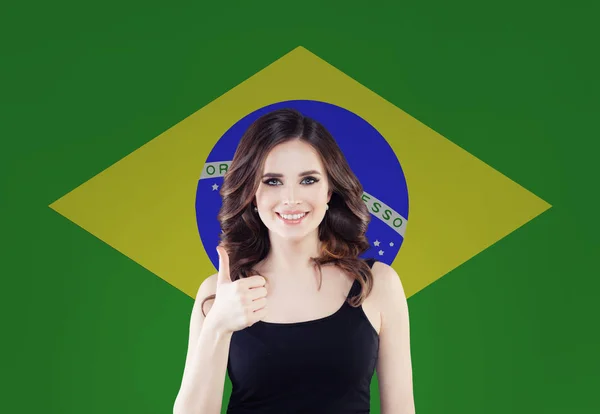 Happy brunette girl dengan jempol sampai berpose melawan bendera Brasil — Stok Foto