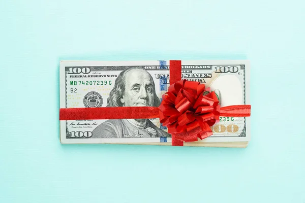 Dinheiro americano pilha de dinheiro com fita vermelha e arco — Fotografia de Stock