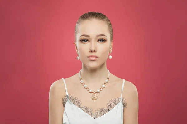 Portrait of gold jewelry model. Pretty woman with pearls earrings