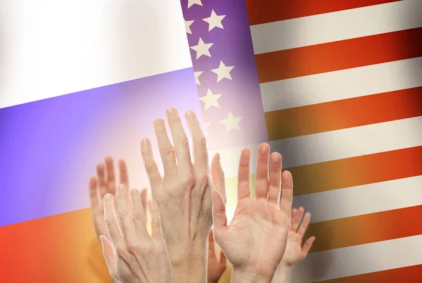 People raising hands on flag Russia and USA background.
