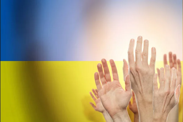 Pessoas levantando as mãos e bandeira Ucrânia em segundo plano . — Fotografia de Stock