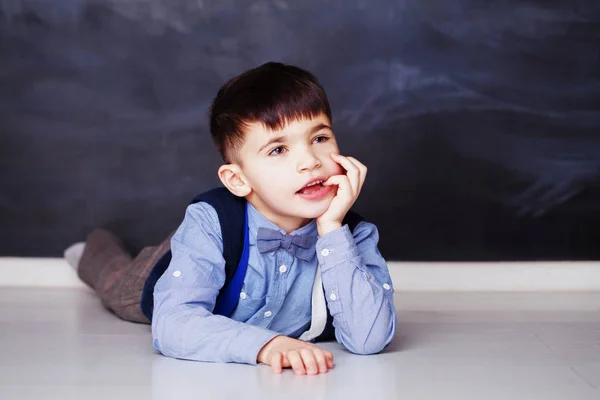 Menino bonito em camisa azul sonhando em casa — Fotografia de Stock