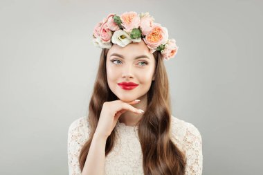 Güzellik modeli kadınla açık cilt, kıvırcık saç, makyaj ve çiçekler